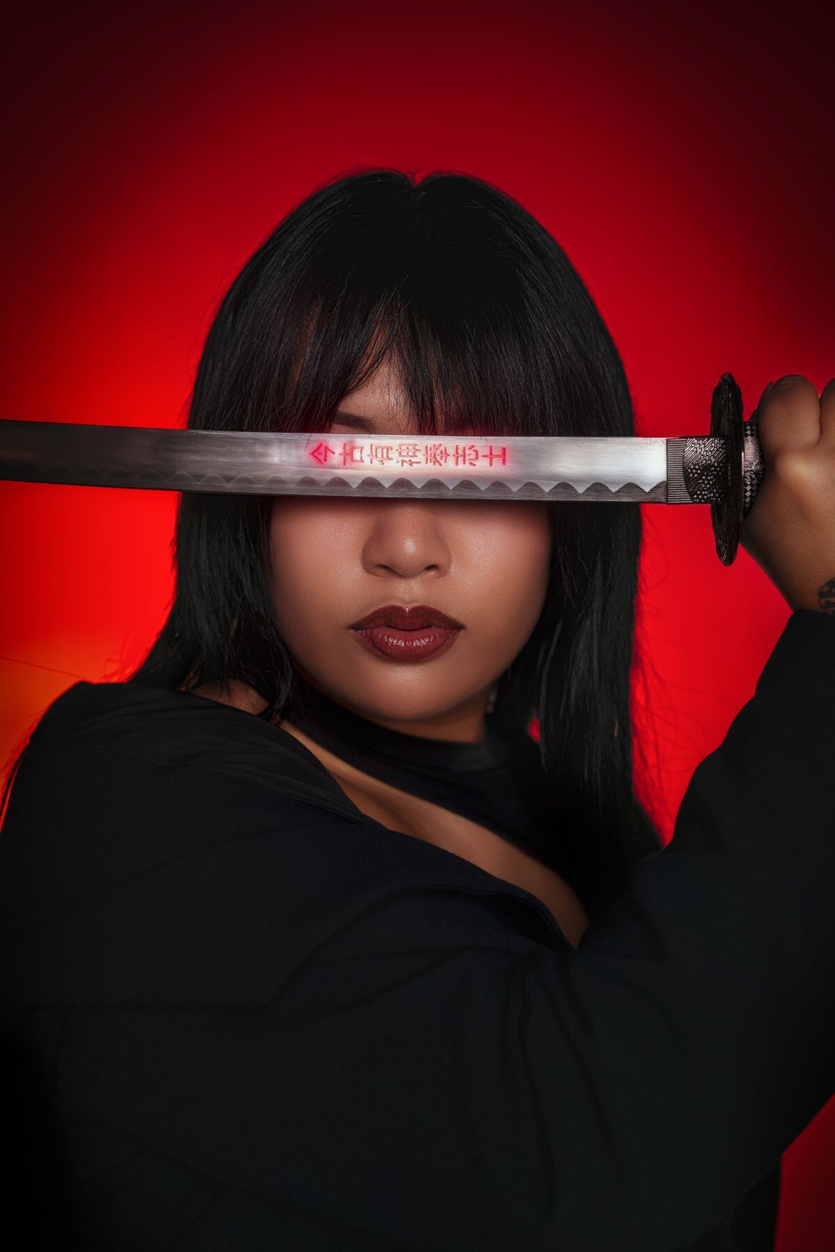 A blade held across a face against a red backdrop