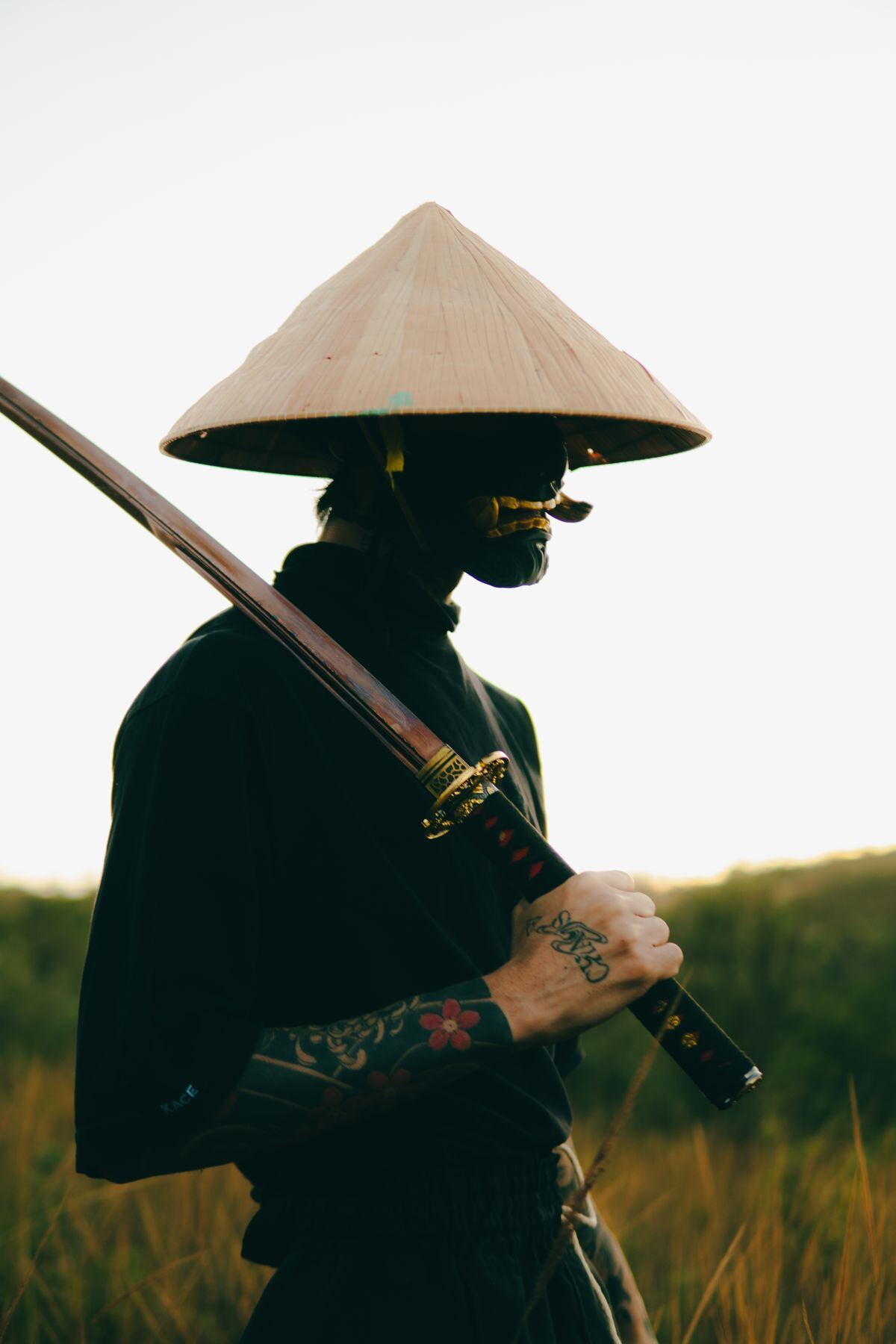 A ronin with a straw hat and katana in the rain