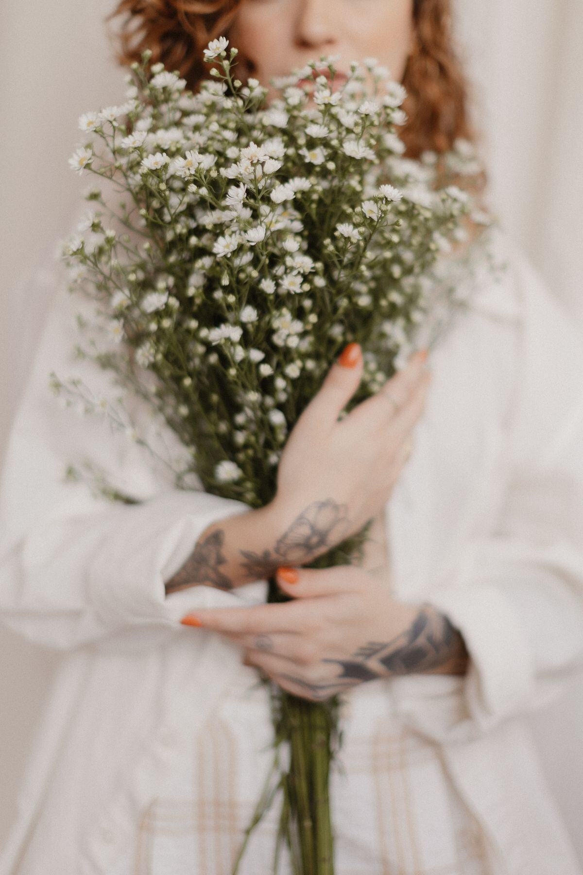 A woman holding a bouquet of white wildflowers