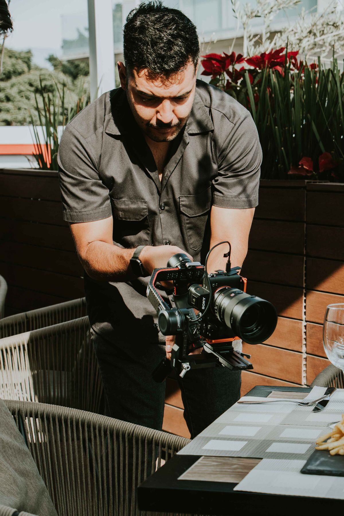 A man filming with a cinema camera in a bright studio