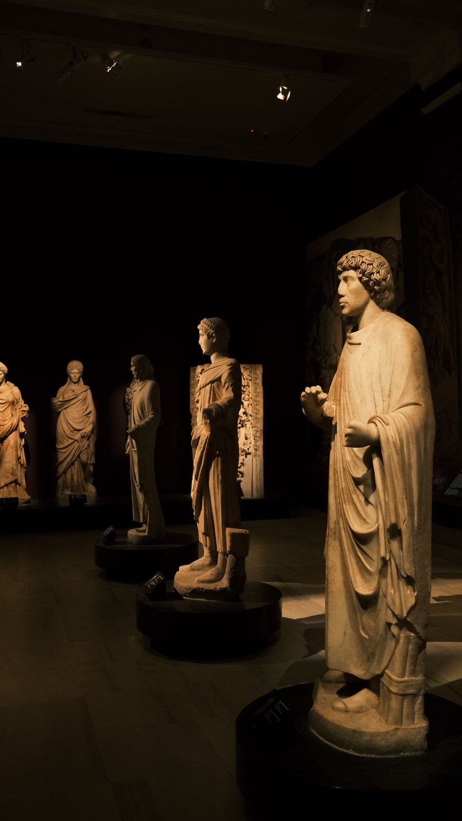 A marble statue in a dim museum gallery