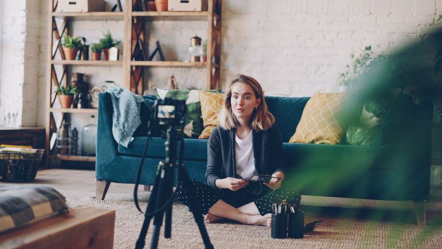 A creator filming herself in a cosy living room