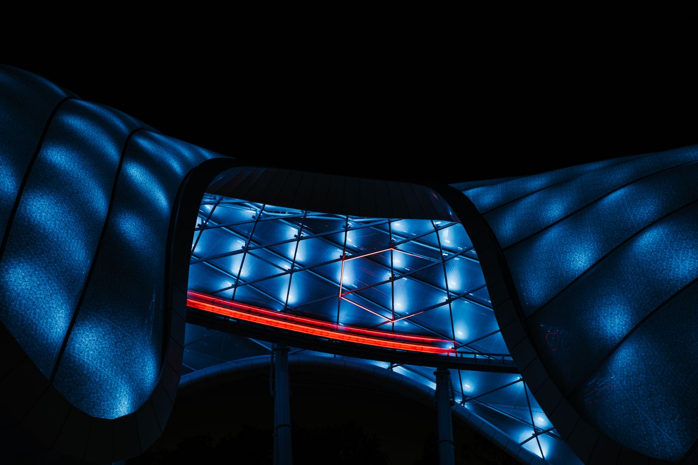 Blue LED lines tracing a curved building facade at night