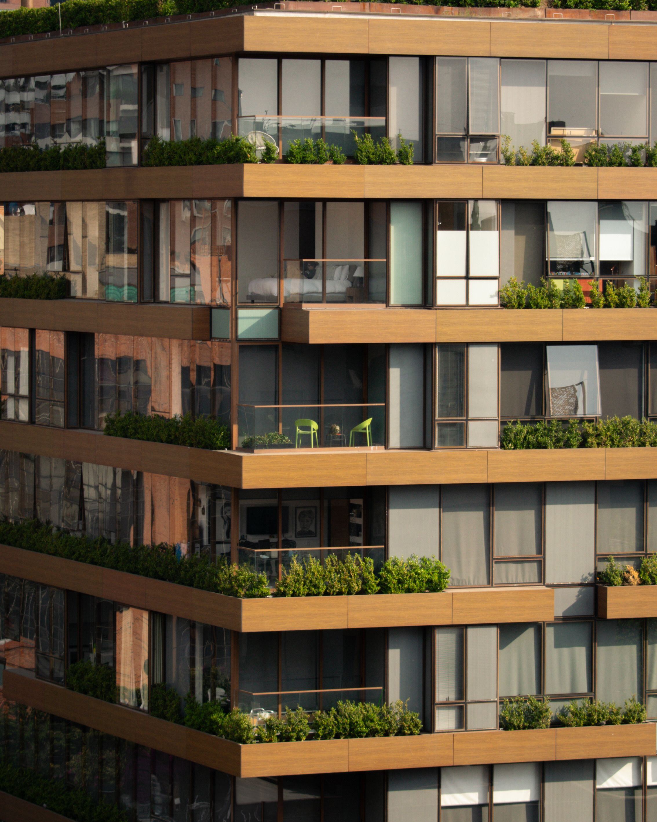 Timber-clad terraces with planted balconies at golden hour