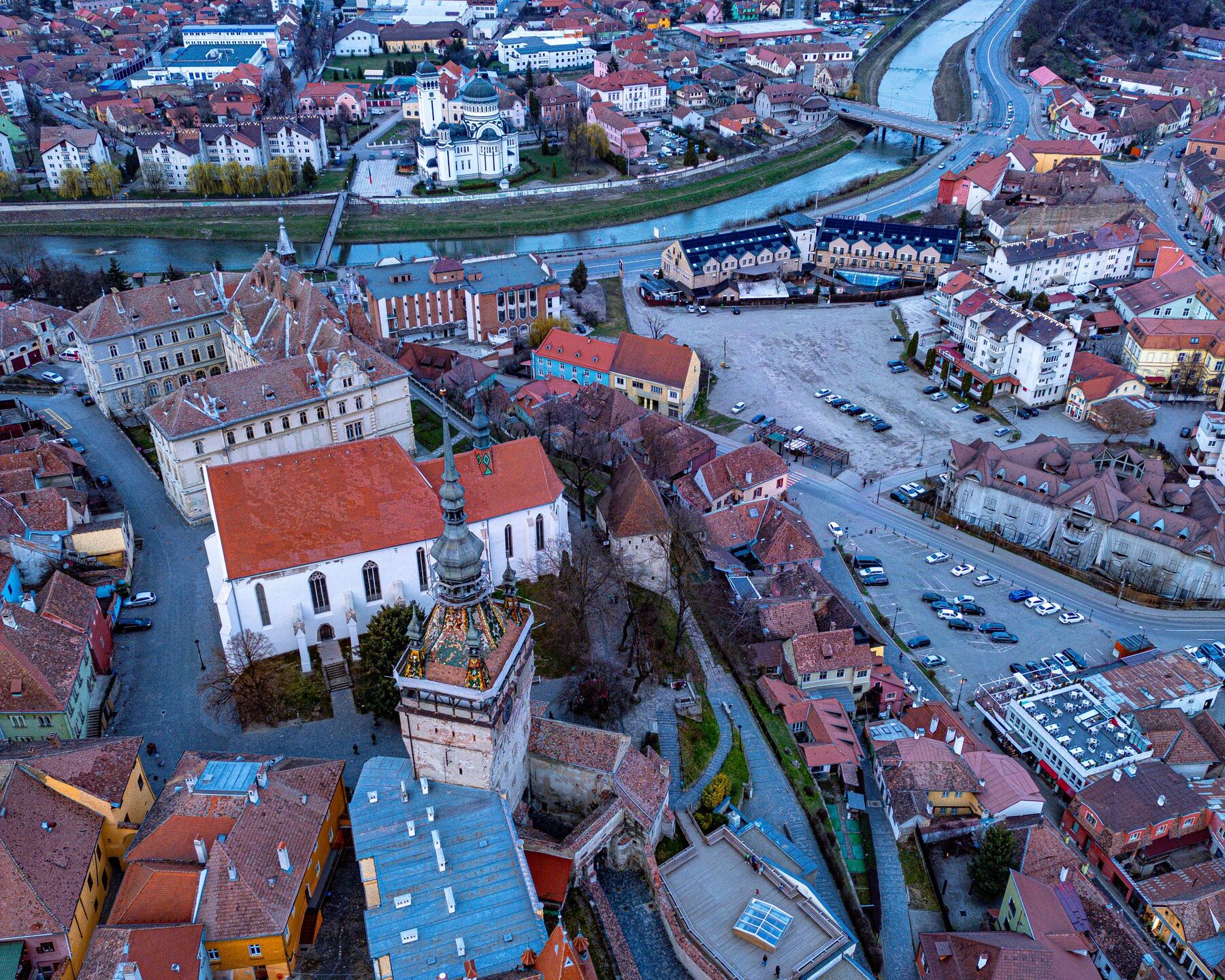 Aerial view of a historic old town with a river, at dusk