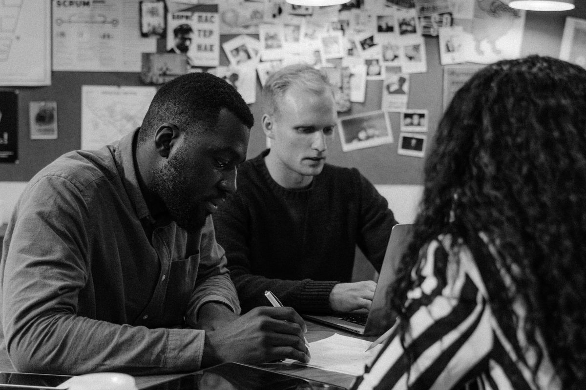A team meeting around a table, in black and white