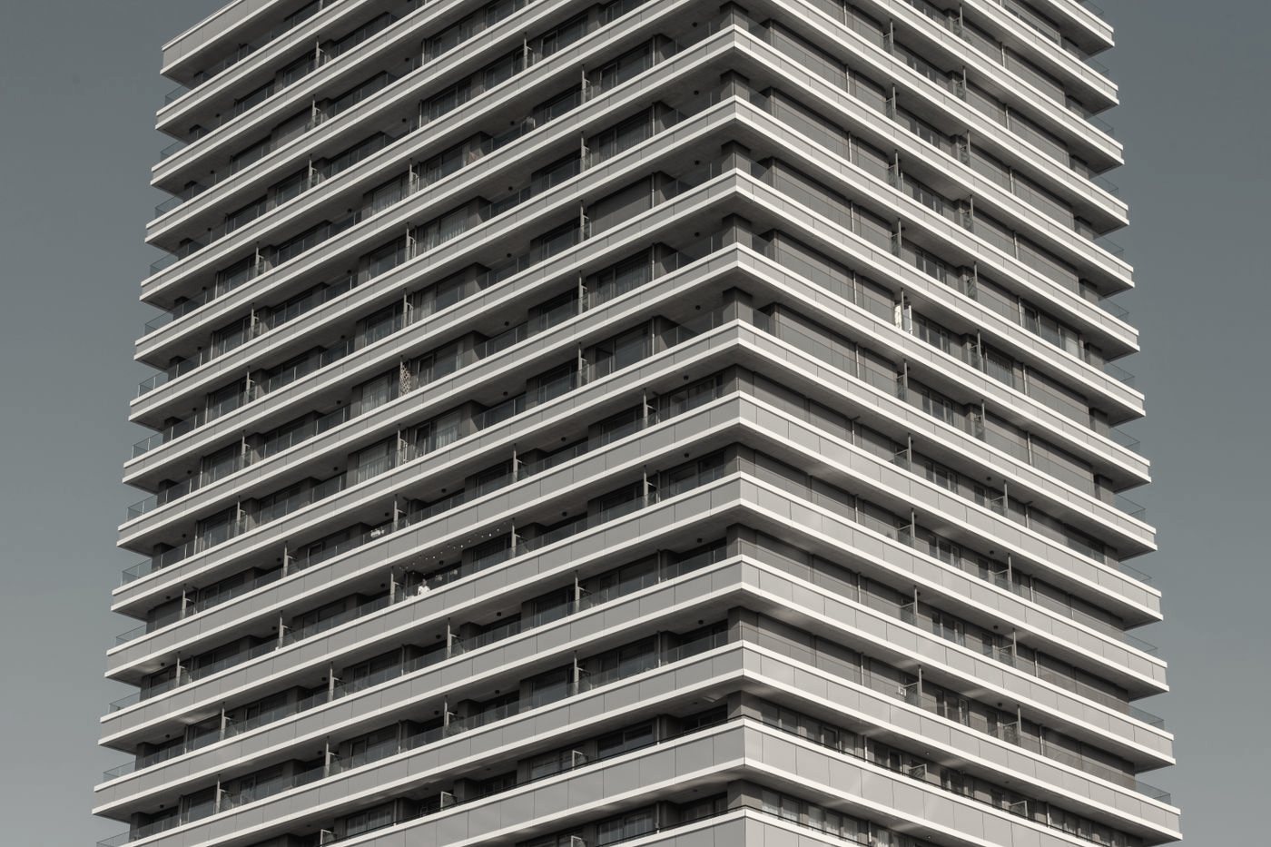 A white residential tower with deep balconies