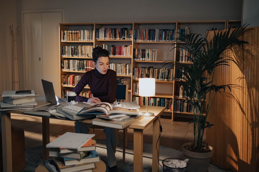 A student reading in a quiet library at night