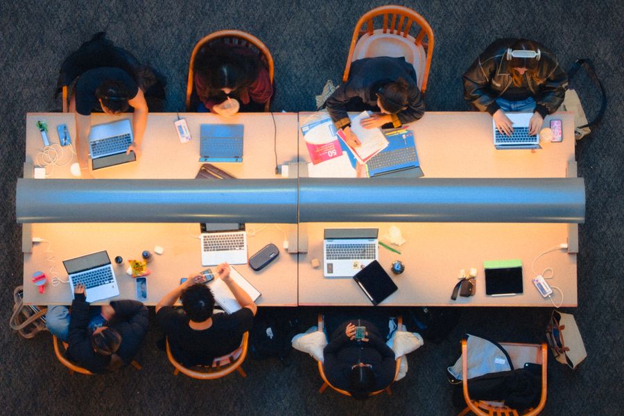 Students studying at long desks seen from above