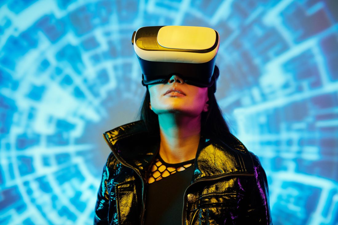 A learner in a gold VR headset against a neon blue background
