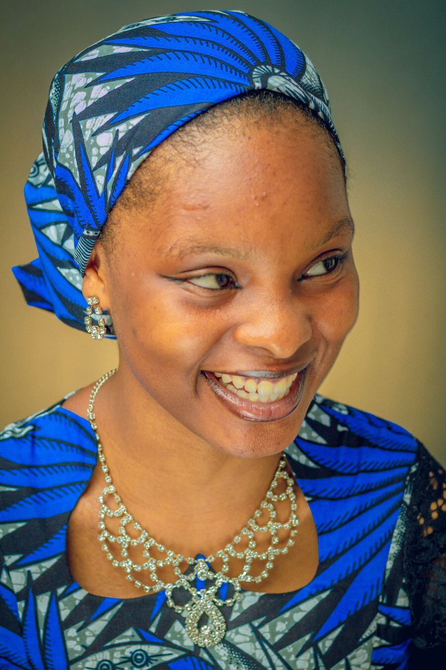 A smiling woman in a blue headscarf