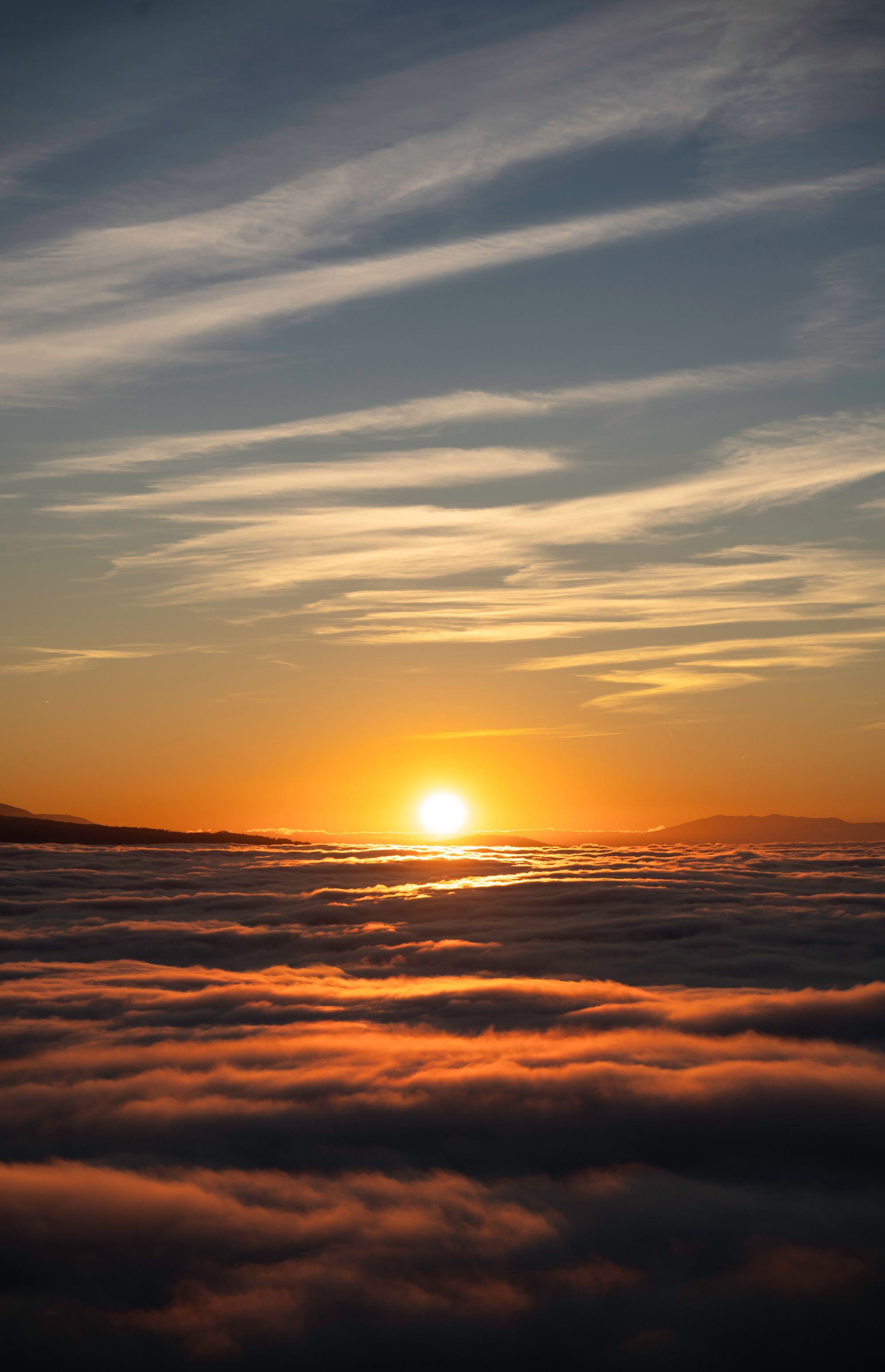 The sun setting over a sea of clouds