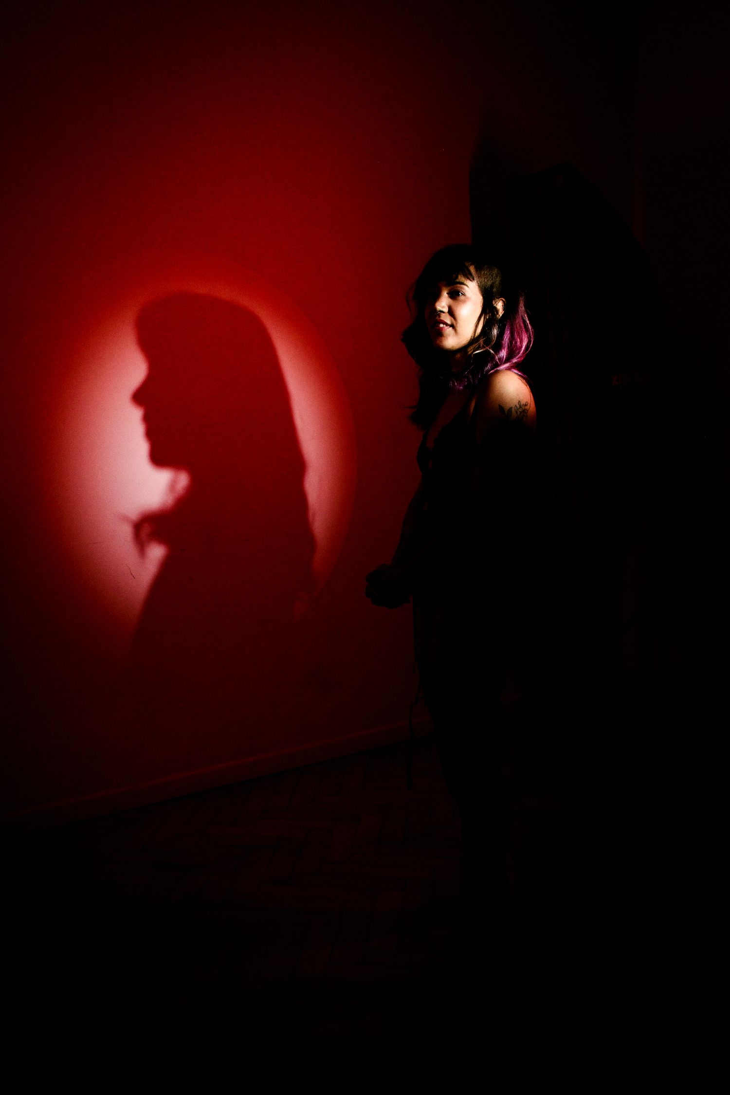 A shadowed portrait lit by a red spotlight