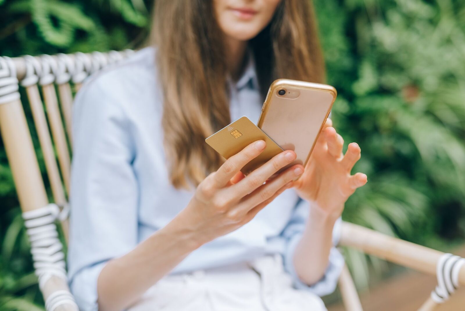 A woman paying with her phone and card in a leafy garden